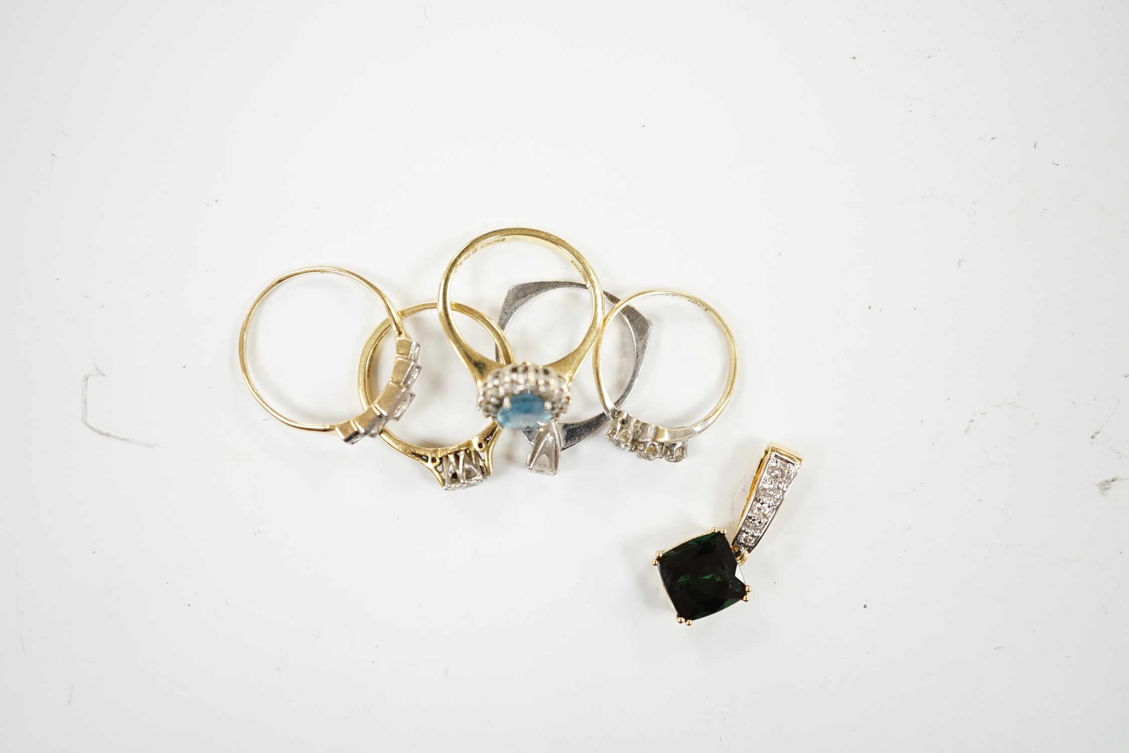 Five assorted modern 18ct and gem set rings, including two solitaire diamond rings and a graduated five stone diamond ring, together with a modern 18ct, green stone and diamond cluster set pendant, gross weight 16 grams.